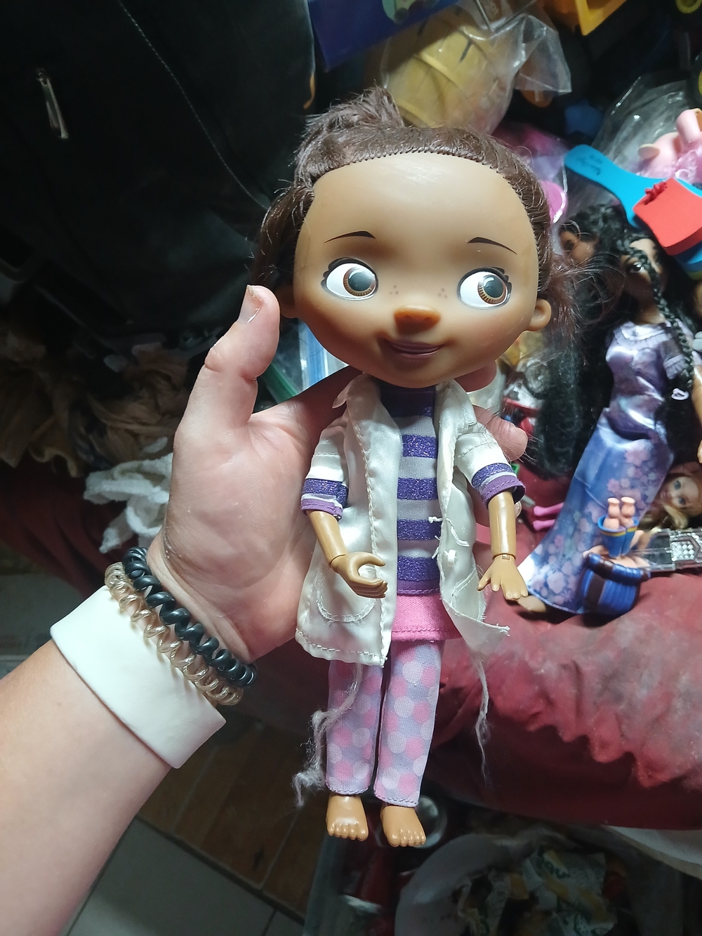 shows a Doc McStuffins Toy Hospital Doc Doll wearing her signature white lab coa